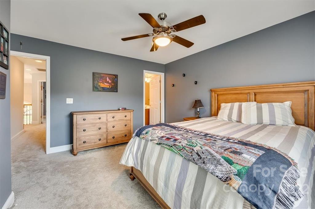 916 Cove Point Lane Tega Cay, SC 29708 - Photo 28 of 48 a bedroom with a bed and a chandelier