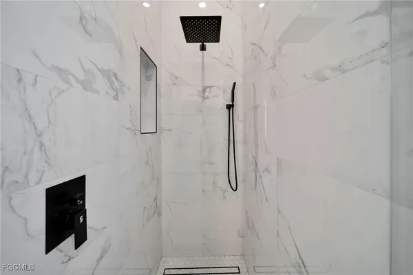 a bathroom with a shower and a tiled wall