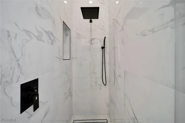 a bathroom with a shower and a tiled wall