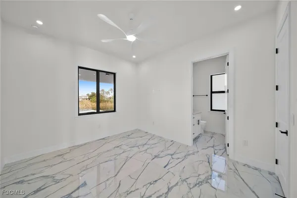 a view of empty room with window and wooden floor