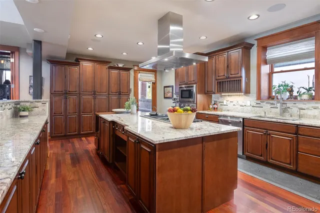 a kitchen with kitchen island granite countertop a sink stove and cabinets