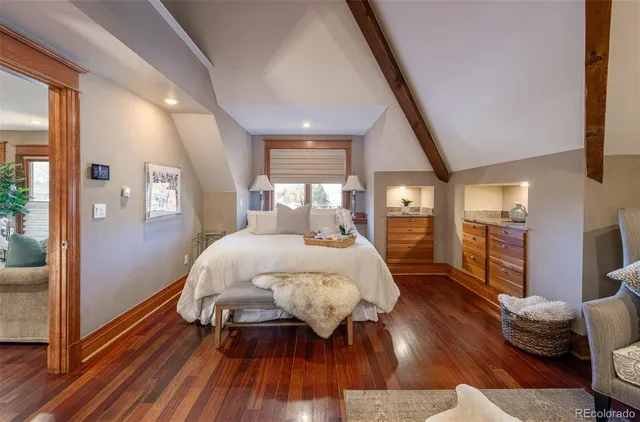 a bed sitting in a spacious bedroom next to a window