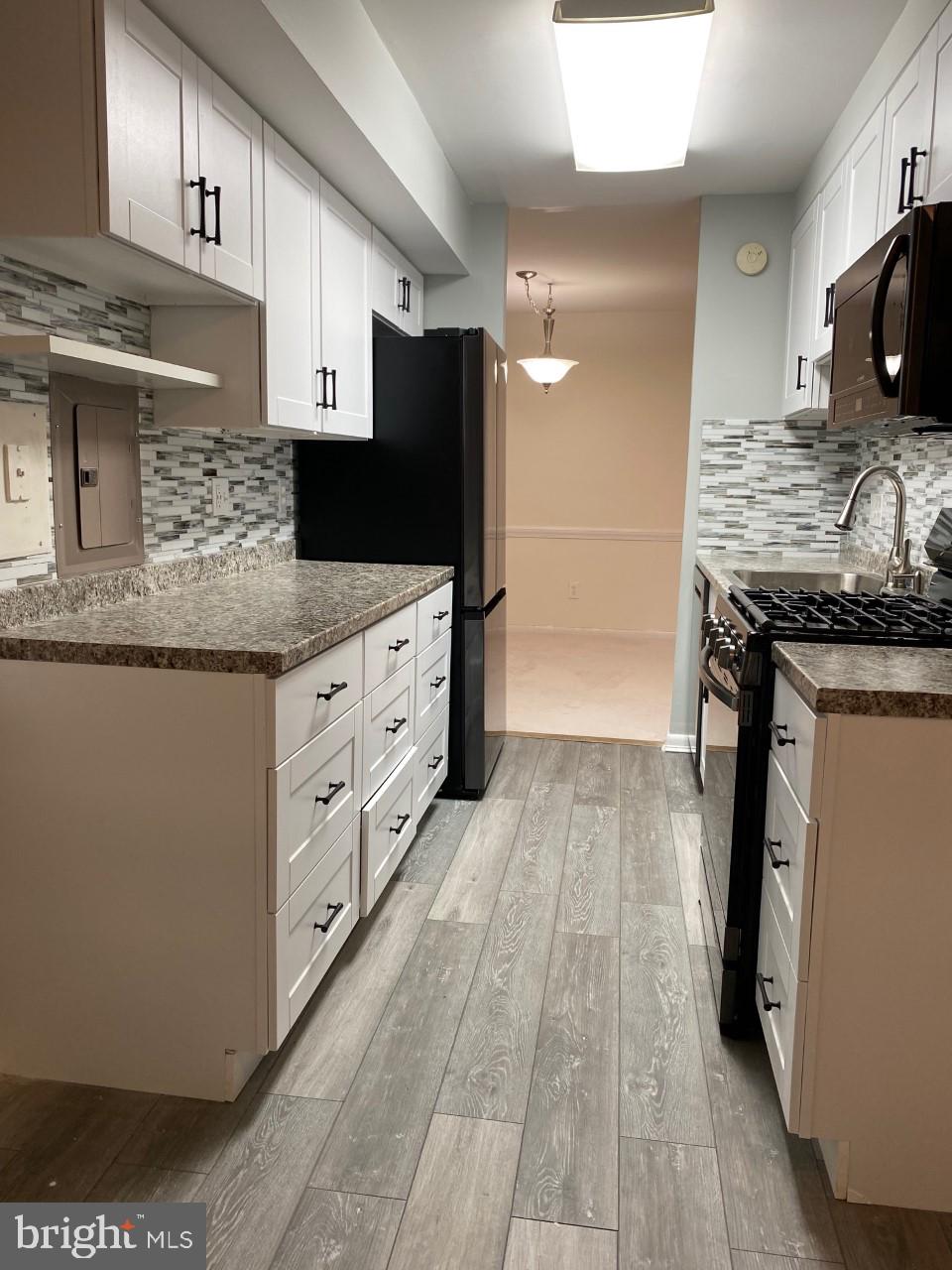 8316 Tobin Road, Unit 13 Annandale, VA 22003 - Photo 3 of 11 a kitchen with granite countertop a refrigerator and a stove top oven
