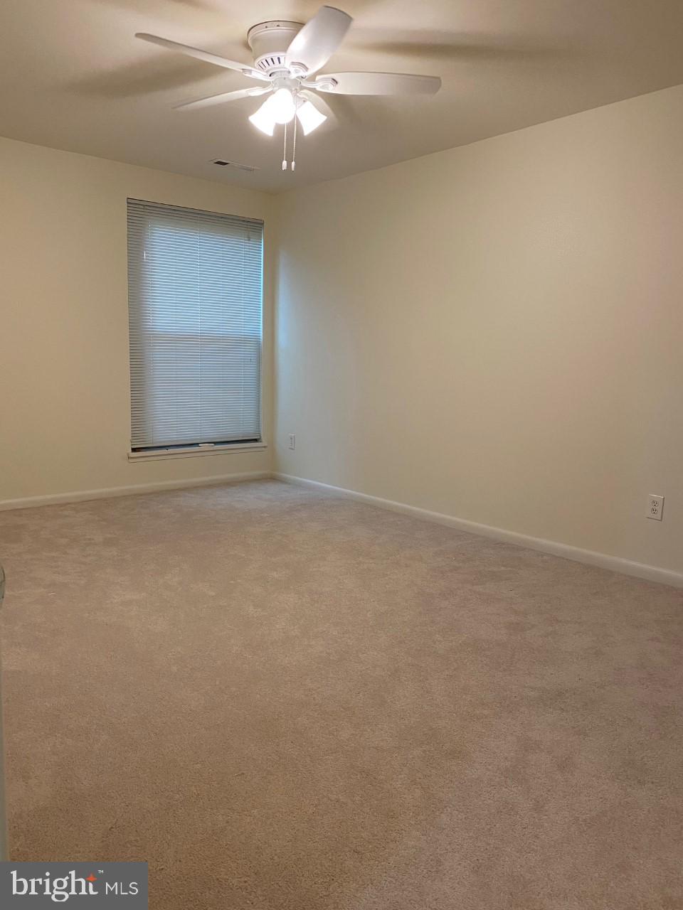 8316 Tobin Road, Unit 13 Annandale, VA 22003 - Photo 6 of 11 an empty room with a chandelier fan and windows