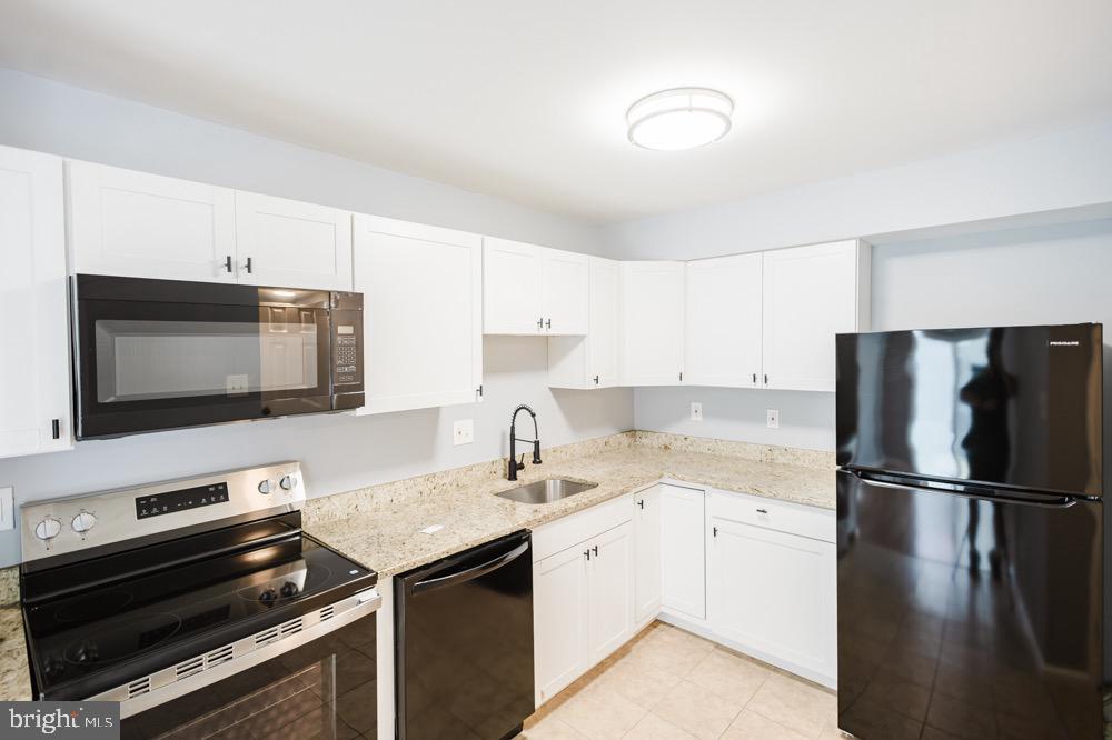 5764 Thunder Hill Road Columbia, MD 21045 - Photo 6 of 16 a kitchen with a sink stove and microwave