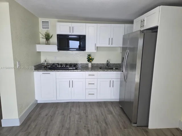 a kitchen with stainless steel appliances a refrigerator sink and microwave