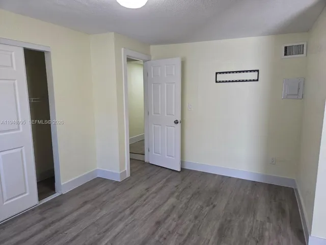 a view of a small space with wooden floor and a window