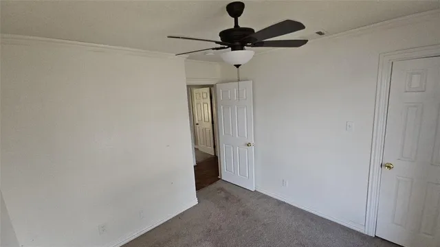 an empty room with wooden floor fireplace and windows