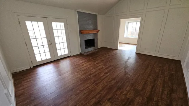 an empty room with wooden floor and fireplace