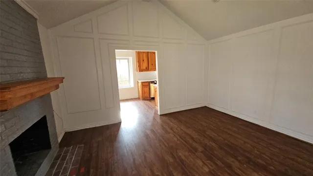 a hallway with wooden floor and staircase