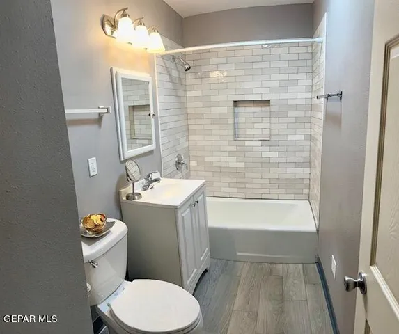 a bathroom with a granite countertop toilet a sink and bathtub