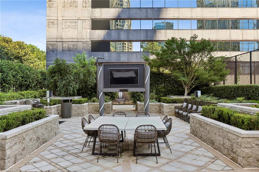 3445 Stratford Road Northeast, Unit 3105 Atlanta, GA 30326 - Photo 35 of 47 a view of a patio with couches table and chairs under an umbrella with large trees