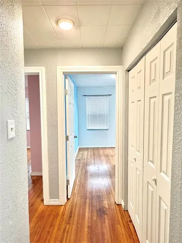 a view of a hallway with wooden floor and staircase