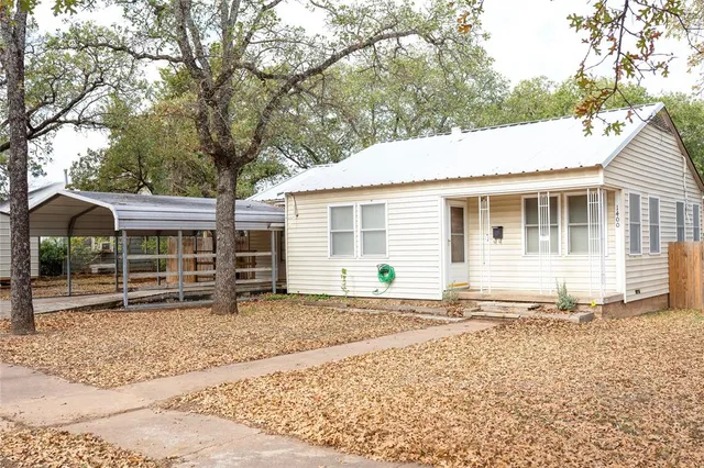 a backyard of a house with barbeque oven table and chairs