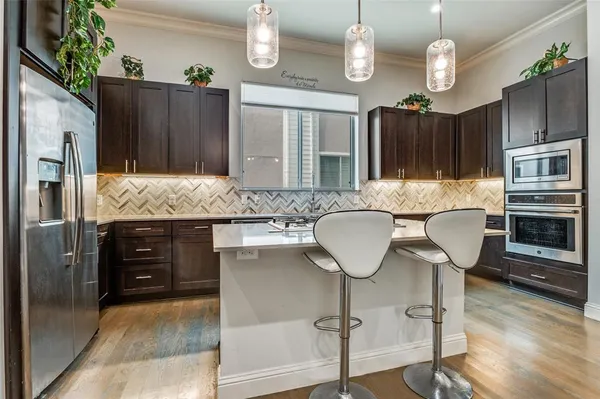 a kitchen with stainless steel appliances granite countertop a refrigerator and a stove top oven