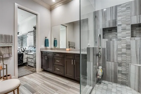 a spacious bathroom with a double vanity sink a mirror and a shower