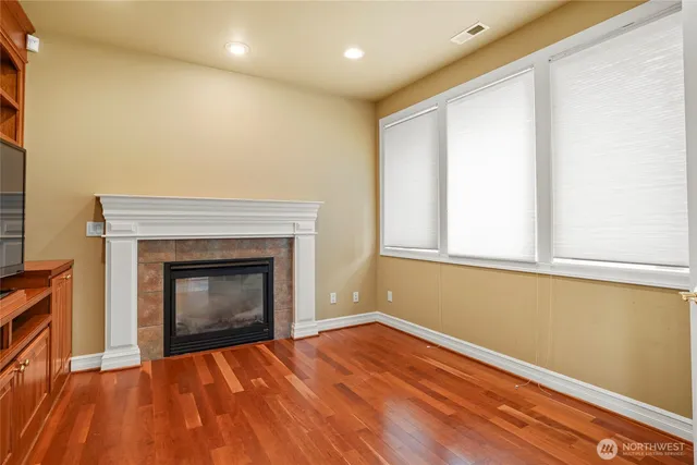 a view of empty room with wooden floor and fireplace