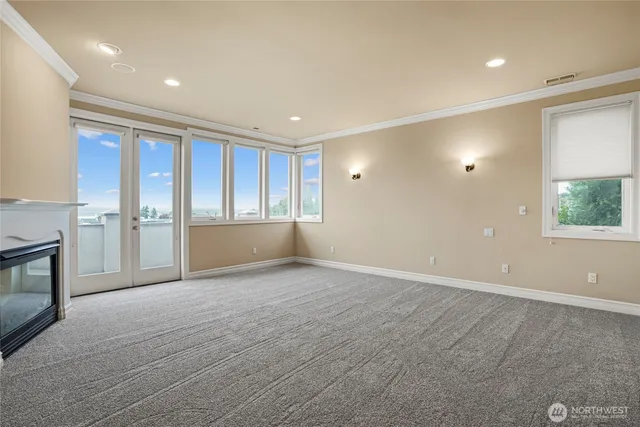 an empty room with windows and fireplace
