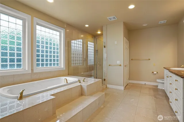 a spacious bathroom with a tub a double vanity sink and a large mirror