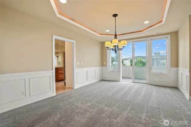 a view of a livingroom with a chandelier fan and windows