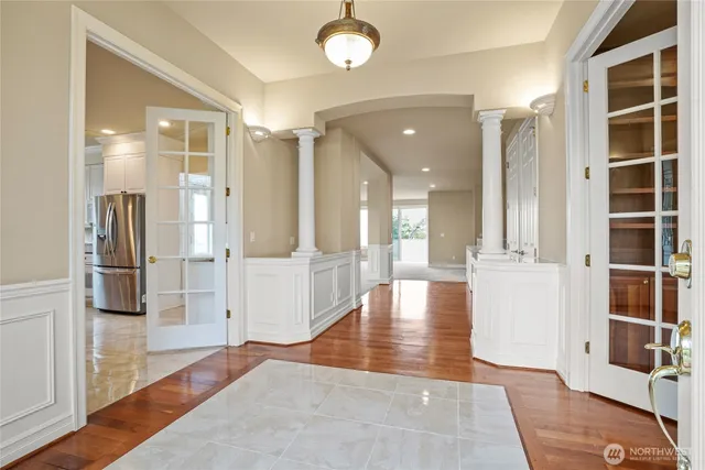a view of a hallway with wooden floor and windows