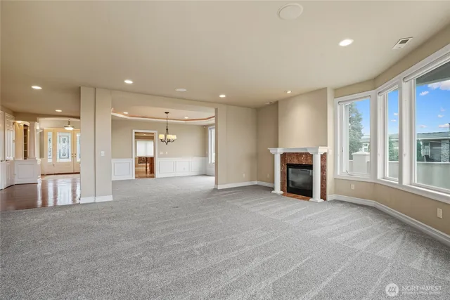 a view of an empty room with a fireplace and a window