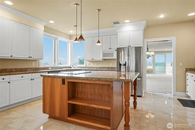 a kitchen with stainless steel appliances granite countertop a refrigerator and a stove top oven