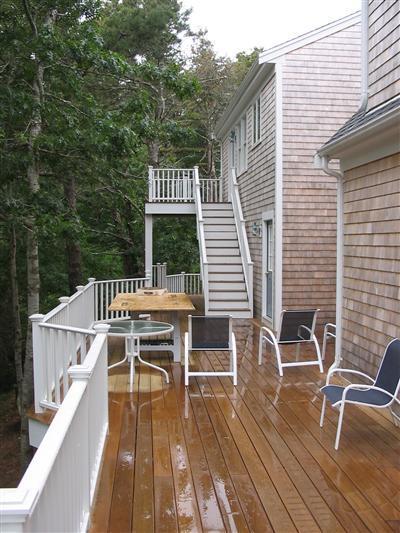 700 Satucket Road Brewster, MA 02631 - Photo 7 of 9 a view of a roof deck with table and chairs with wooden floor and fence