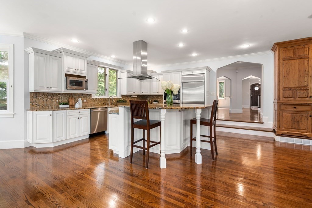 15 Fredana Road Newton, MA 02468 - Photo 7 of 25 a kitchen with stainless steel appliances kitchen island granite countertop wooden floors and white cabinets