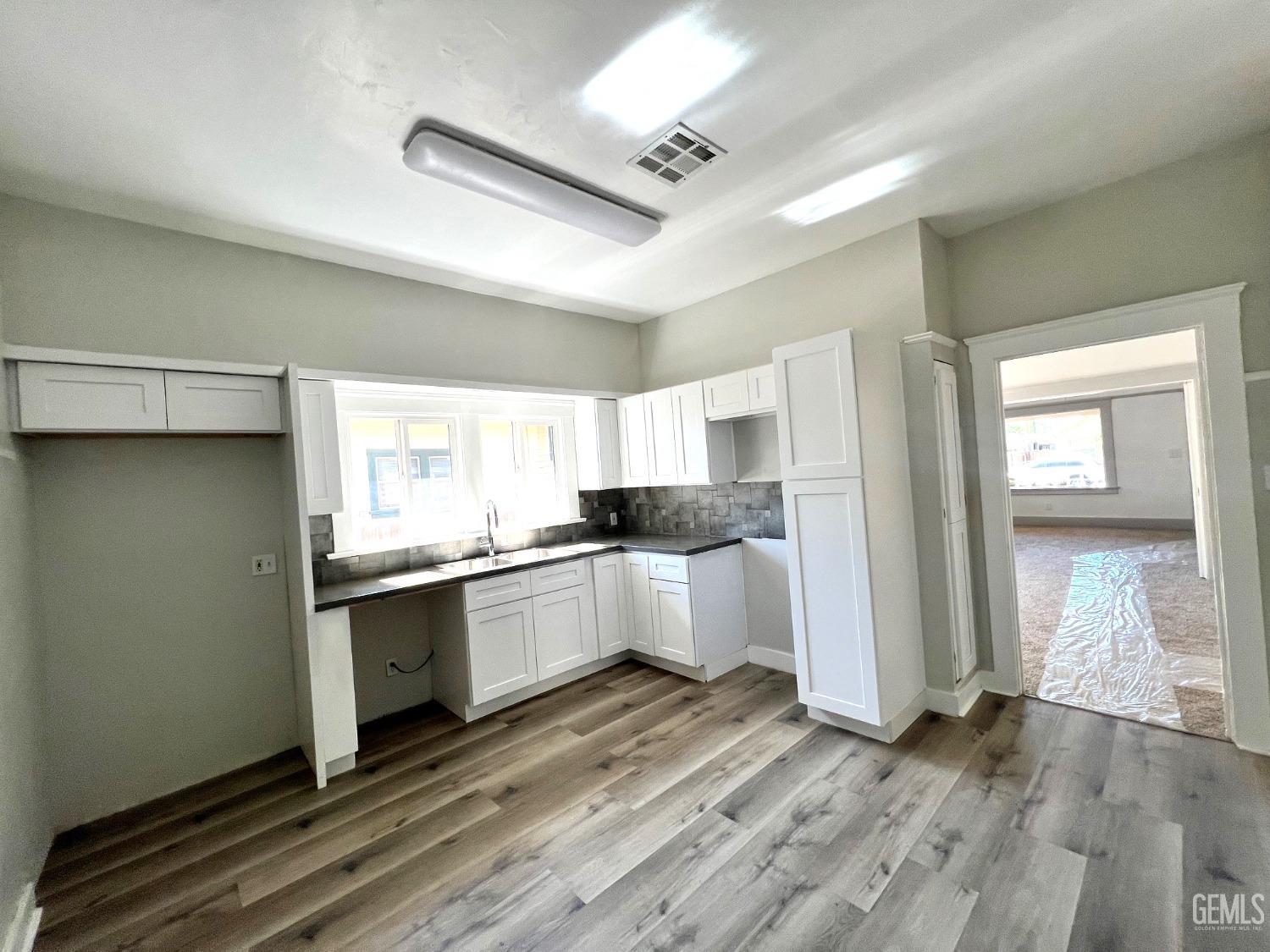 Undisclosed Address Bakersfield, CA 93304 - Photo 17 of 38 a kitchen with granite countertop white cabinets and white appliances