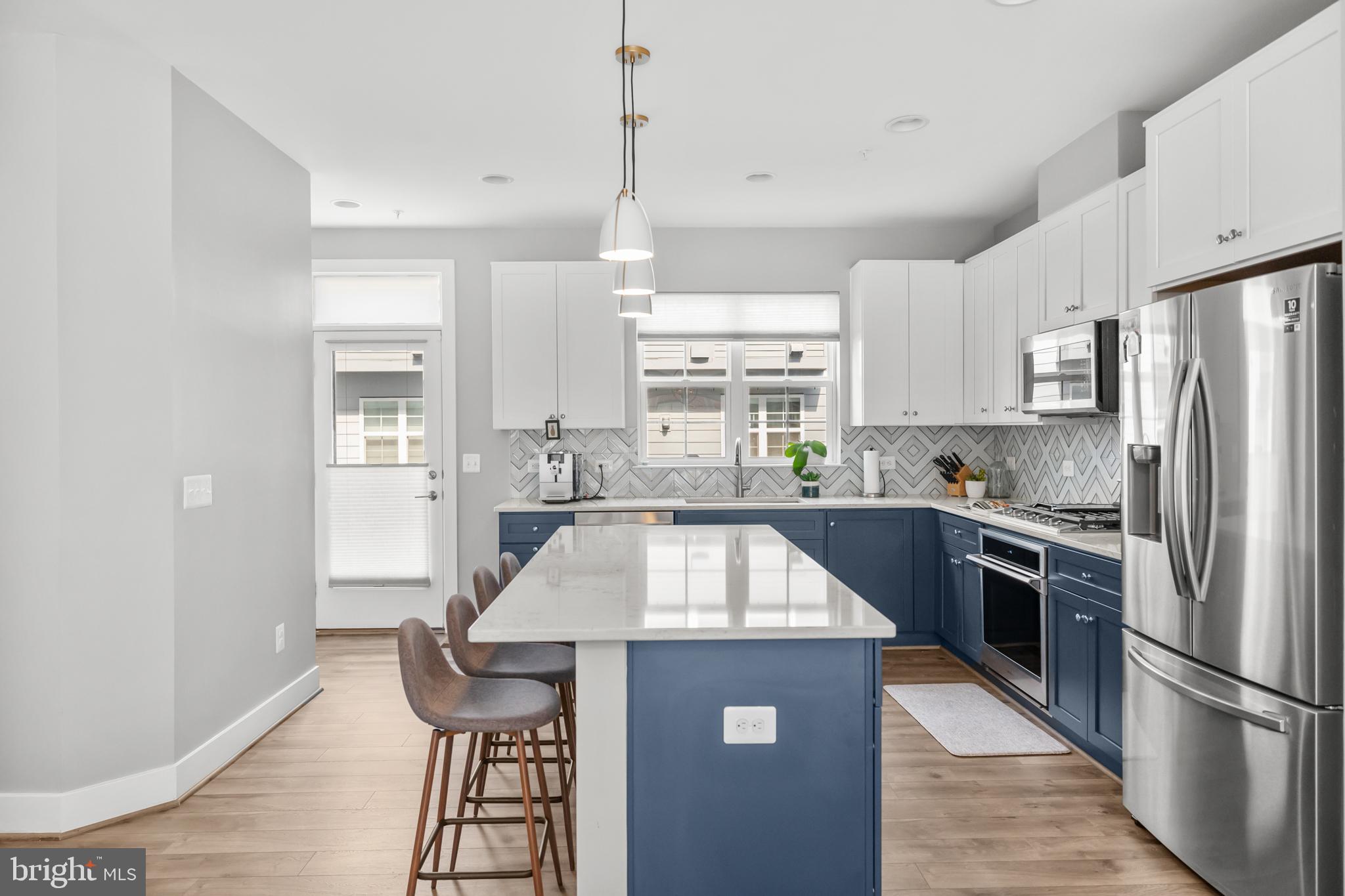 11226 Beaker Street Reston, VA 20190 - Photo 8 of 53 a kitchen with kitchen island a counter top space a sink stainless steel appliances and cabinets