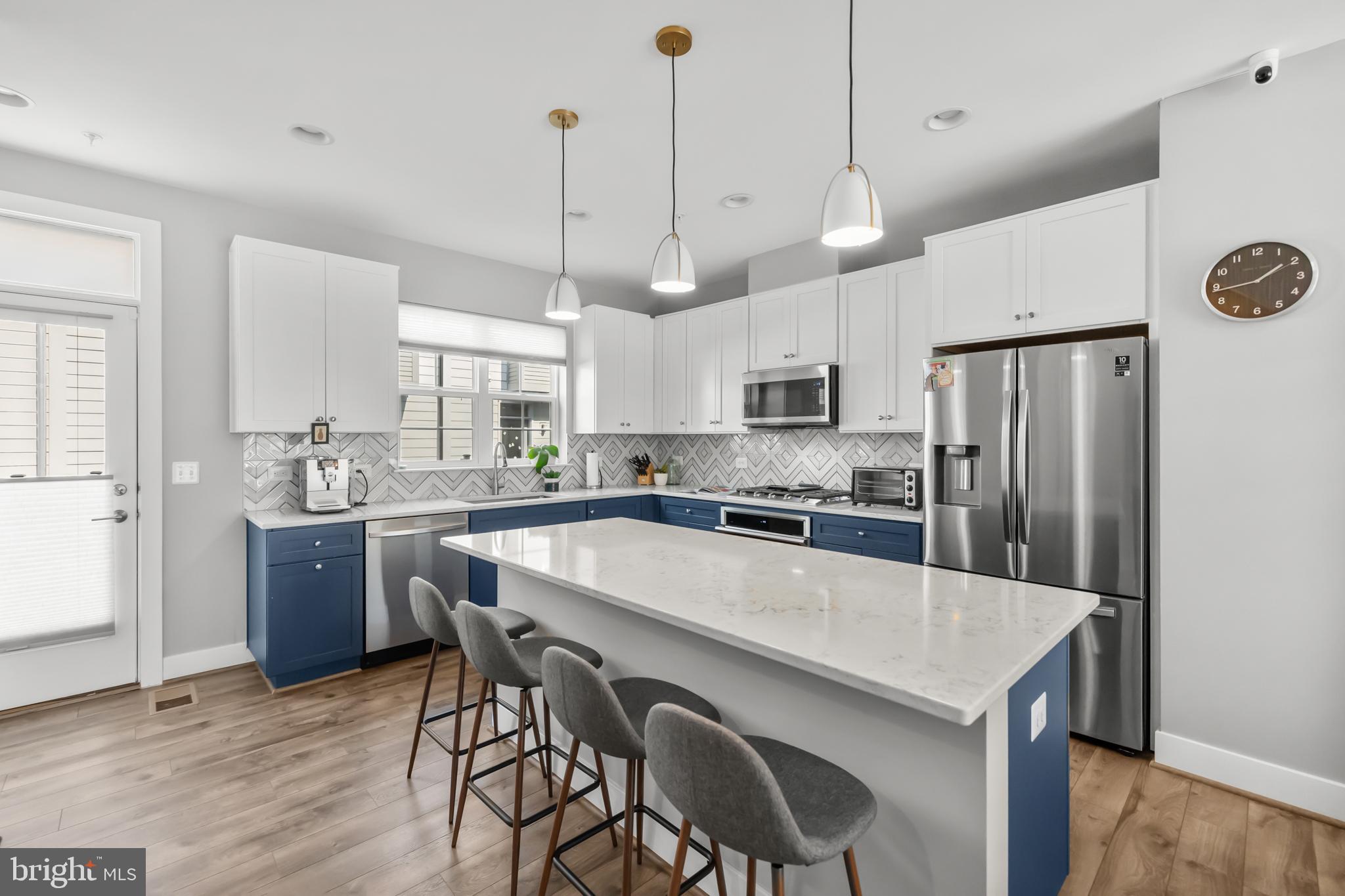 11226 Beaker Street Reston, VA 20190 - Photo 9 of 53 a kitchen with kitchen island a refrigerator a stove a sink and a center island