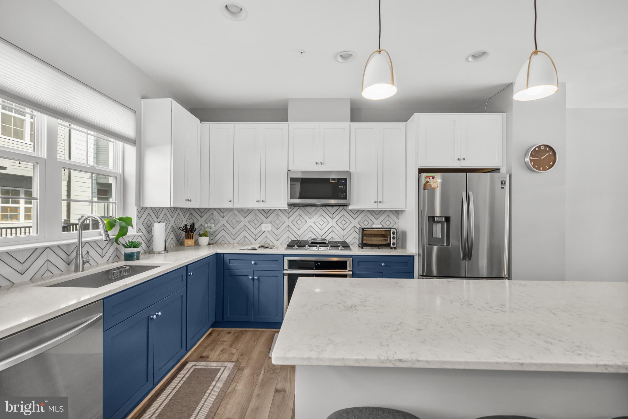11226 Beaker Street Reston, VA 20190 - Photo 10 of 53 a kitchen with stainless steel appliances granite countertop a sink a stove a refrigerator cabinets and a window