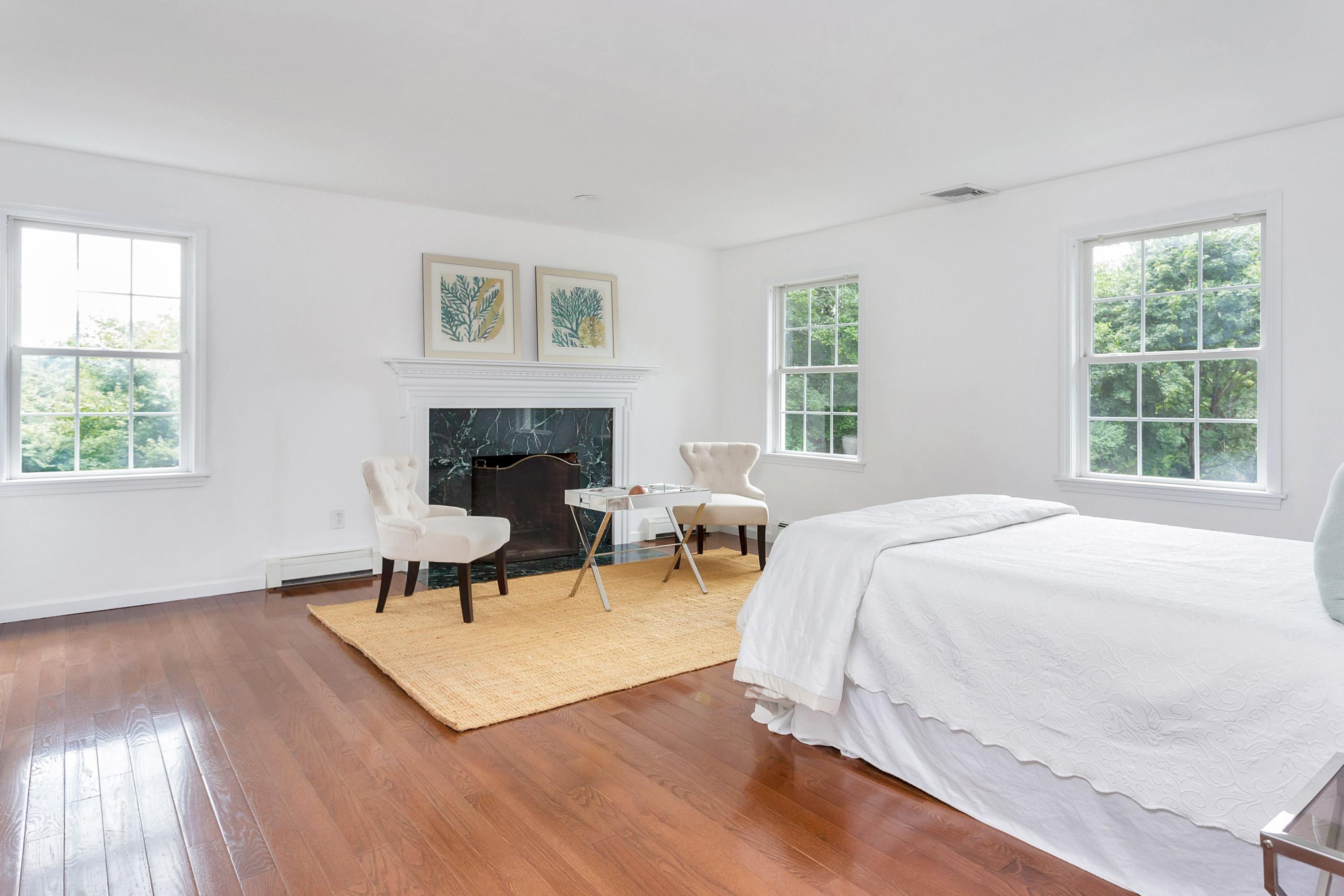 28 Dickinson Road Darien, CT 06820 - Photo 23 of 42 a bedroom with a bed and a fireplace