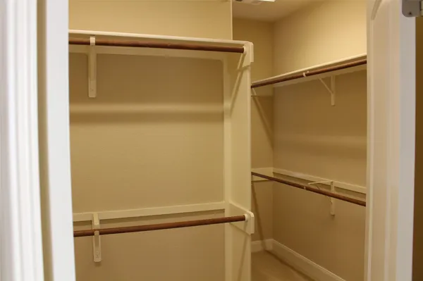a view of an empty room with closet and wooden floor