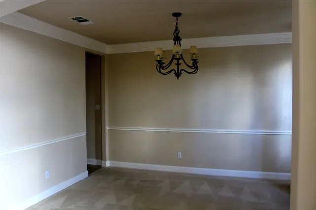 a view of a hallway with wooden floor and a kitchen