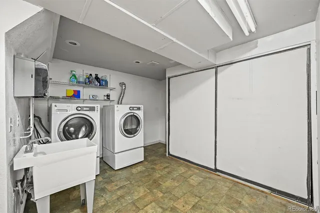 an aerial view of a house with yard and trees in the background