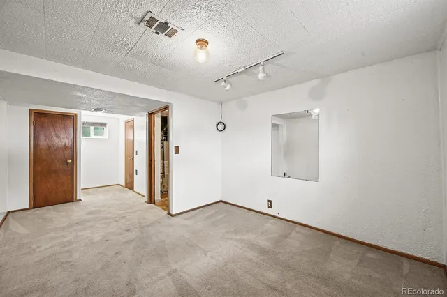 an aerial view of a city with lots of residential buildings and mountain view in back