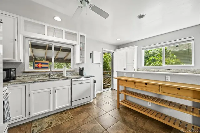 a kitchen with stainless steel appliances a stove a sink and white cabinets