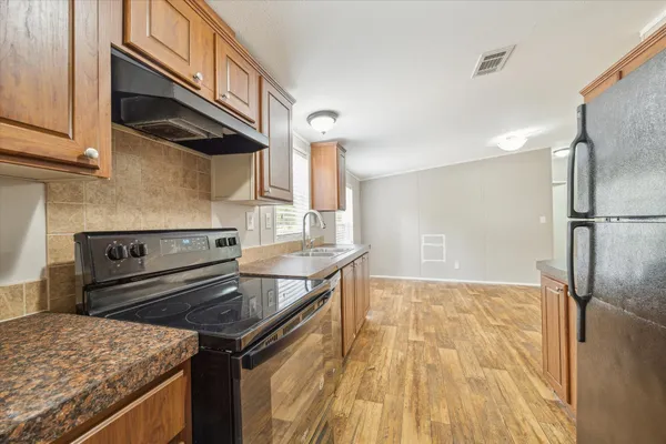 a kitchen with granite countertop a sink stove and refrigerator