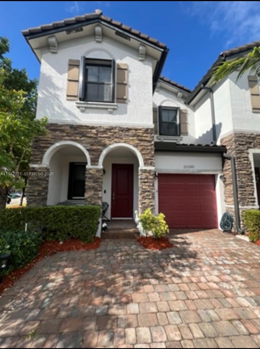 a front view of a house with a yard and garage