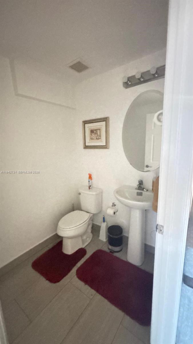 25380 Southwest 115th Court Homestead, FL 33032 - Photo 7 of 32 a bathroom with a toilet sink and mirror