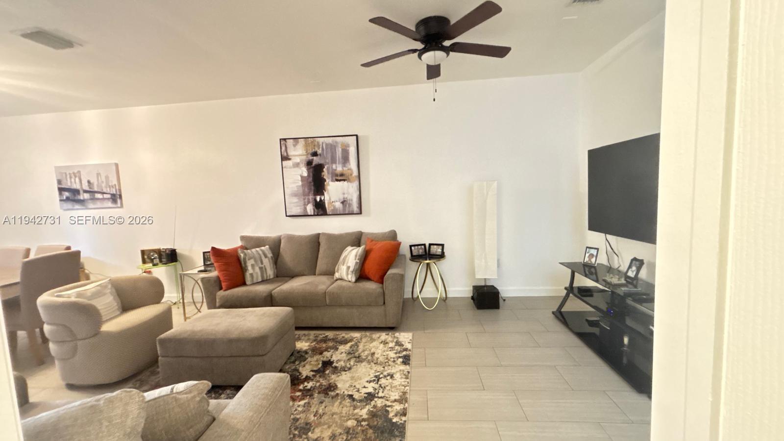 25380 Southwest 115th Court Homestead, FL 33032 - Photo 8 of 32 a living room with furniture and a flat screen tv