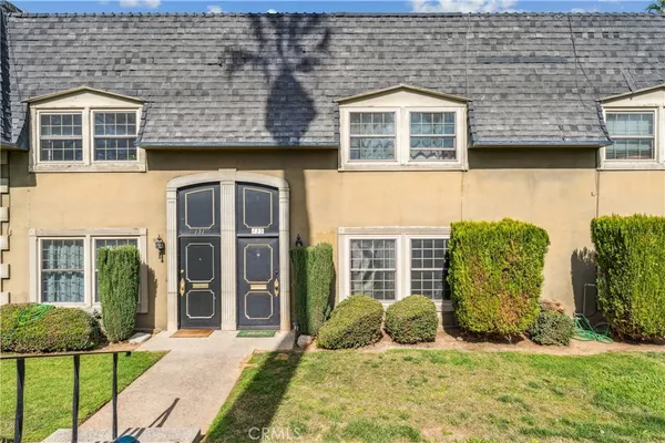 front view of a brick house with a yard