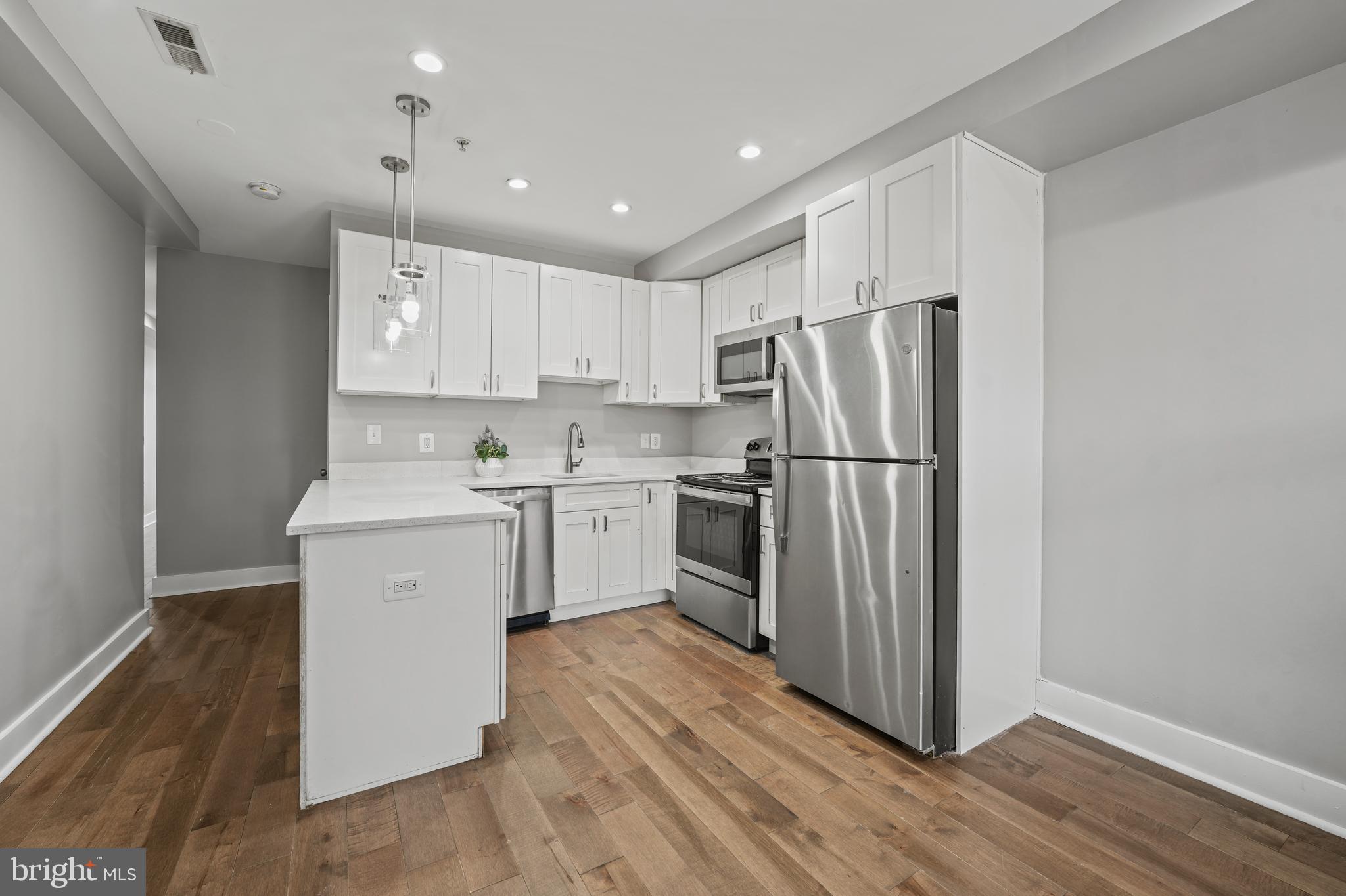 a kitchen with a refrigerator sink and cabinets