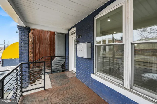 a view of a hallway with wooden floor and glass door