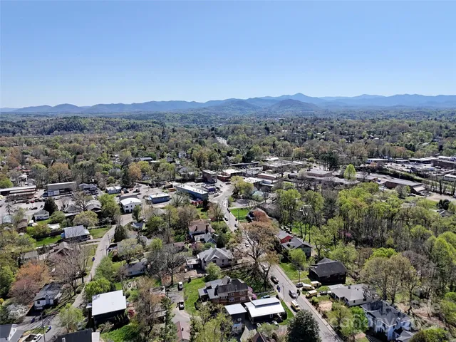 an aerial view of residential houses with outdoor space and trees