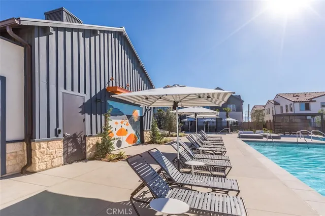 a view of a swimming pool with a lawn chairs under an umbrella