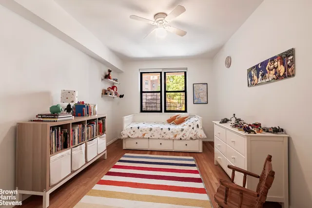 a living room with a baby crib furniture and a window