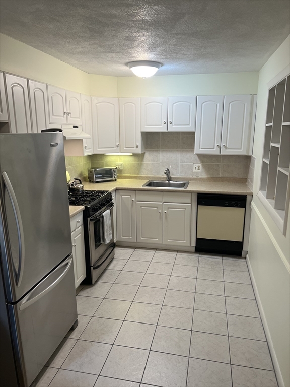 20 Colonial Drive, Unit 3 Andover, MA 01810 - Photo 6 of 24 a kitchen with stainless steel appliances granite countertop a refrigerator sink and cabinets